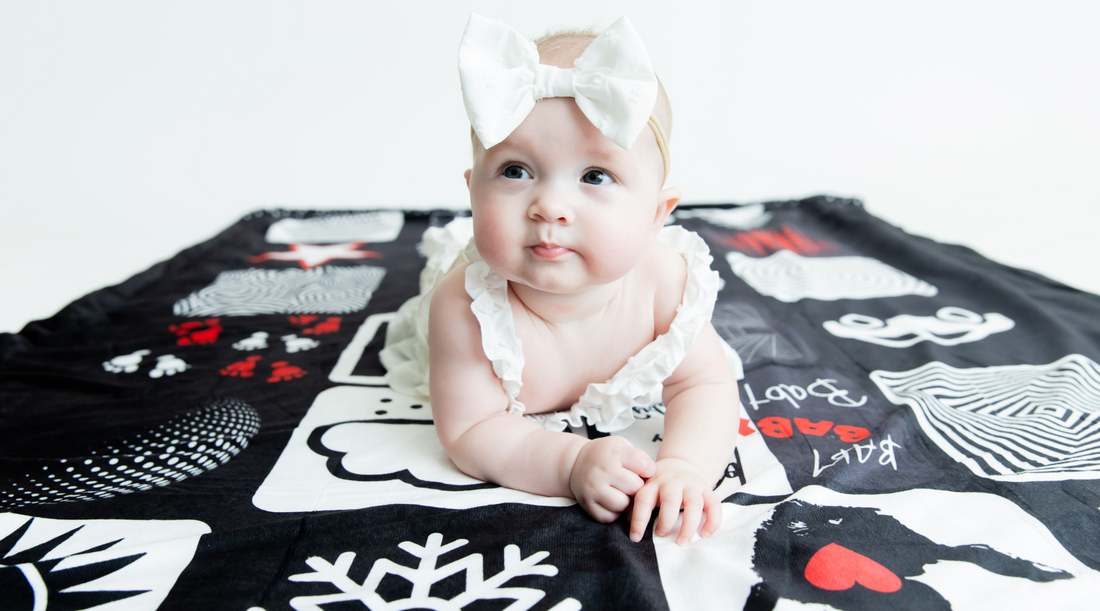 Baby laying on high contrast floor blanket