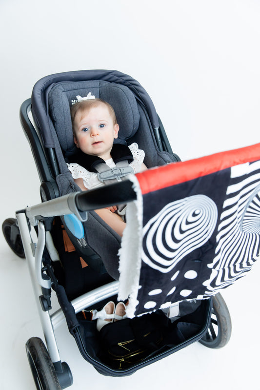 Baby Geometrics high-contrast blanket on a stroller ride, showcasing bold black-and-white patterns designed to stimulate visual development and provide cozy comfort.